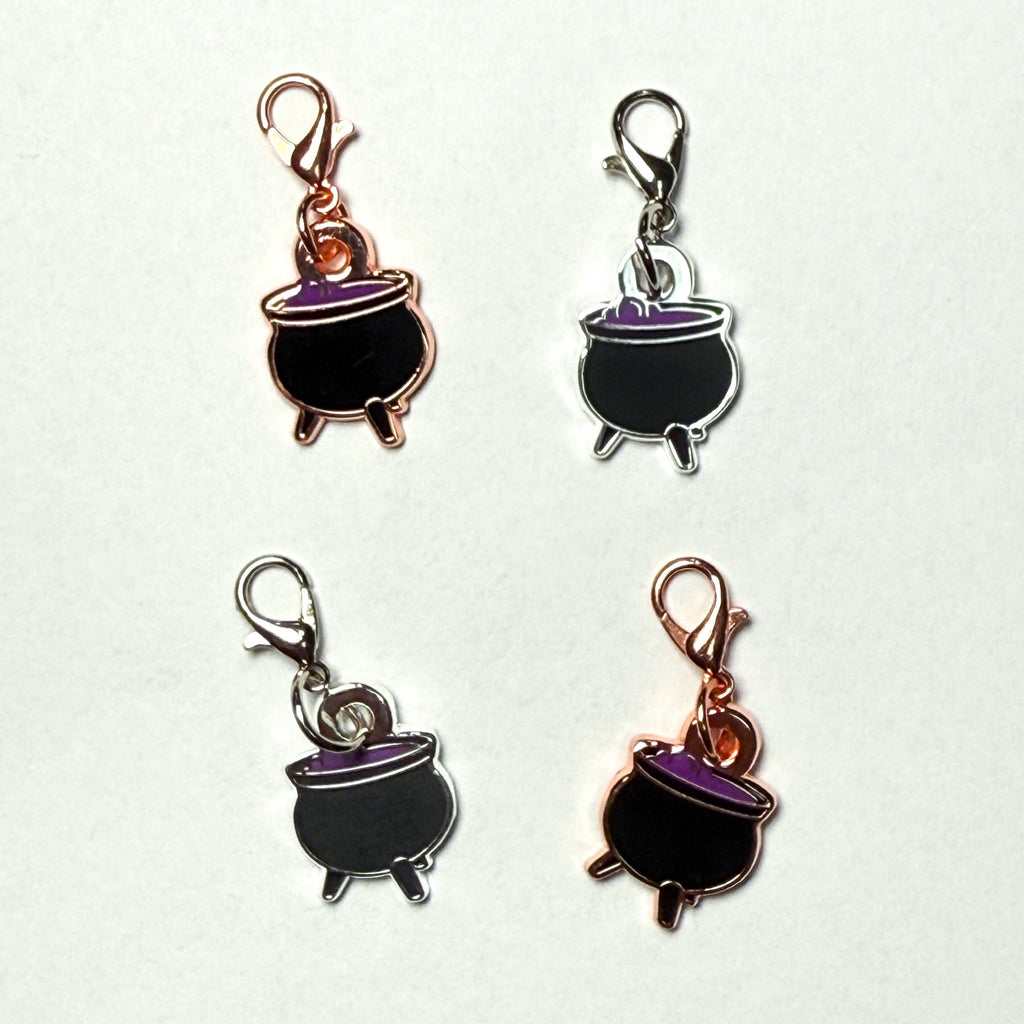 Four cauldron-shaped charms on a white background
