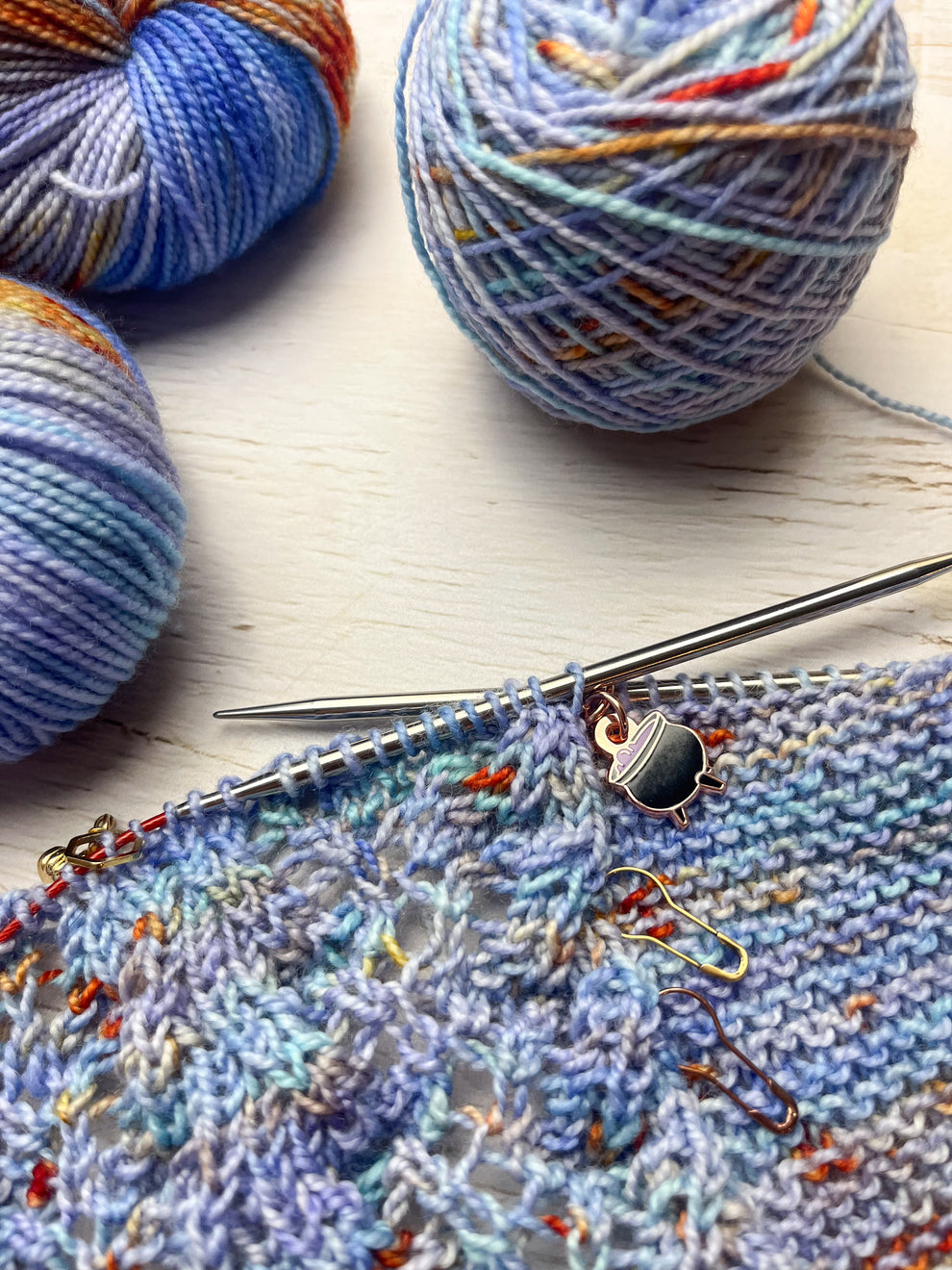 Knitted fabric with yarn and knitting needles on a wooden surface